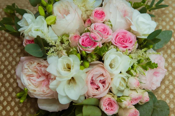Sortija de boda en oro blanco. Dos anillos de platino de la novia y el novio y un ramo de rosas rosadas y flores blancas —  Fotos de Stock