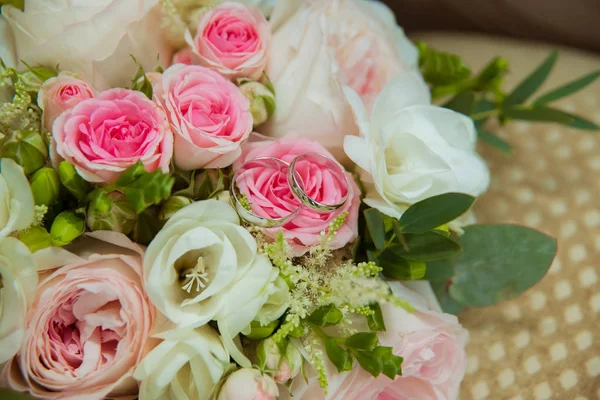 Bague de mariage en or blanc. Deux anneaux de platine des mariés et un bouquet de roses roses et de fleurs blanches — Photo
