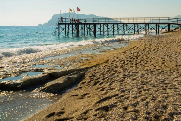 Προβλήτα στην παραλία με χρυσή άμμο και μπλε της θάλασσας για τις καλοκαιρινές διακοπές. Αλάνια, Ασία περιοχή, Τουρκία, Αττάλεια — Φωτογραφία Αρχείου