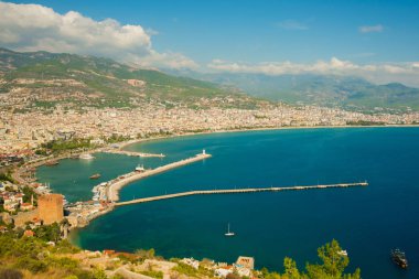 «Ana sayfa» şehir görüntüsü: mavi deniz, dağlar, deniz feneri, duvarlar ve bağlantı noktası. Alanya Yarımadası, Antalya bölgesinde, Türkiye, Asya