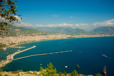 «Ana sayfa» şehir görüntüsü: mavi deniz, dağlar, deniz feneri, duvarlar ve bağlantı noktası. Alanya Yarımadası, Antalya bölgesinde, Türkiye, Asya