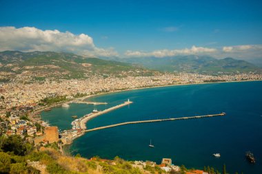 Güzel manzara yukarıdan şehir: mavi deniz, dağlar, deniz feneri, duvarlar ve bağlantı noktası. Alanya Yarımadası, Antalya bölgesinde, Türkiye, Asya