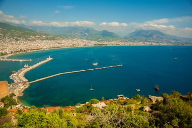 Güzel manzara yukarıdan şehir: mavi deniz, dağlar, deniz feneri, duvarlar ve bağlantı noktası. Alanya Yarımadası, Antalya bölgesinde, Türkiye, Asya
