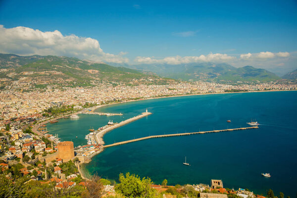 Beautiful landscape top view of the city: the blue sea, mountains, lighthouse, walls and port. Alanya peninsula, Antalya district, Turkey, Asia