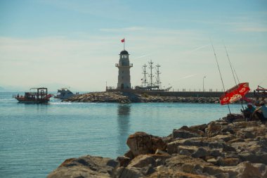 Korsan tarzı gemi ve Alanya sahil kapalı bir deniz feneri. Deniz ve dağlar ufukta. Alanya Yarımadası, Antalya bölgesinde, Türkiye, Asya