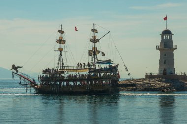 Korsan tarzı gemi ve Alanya sahil kapalı bir deniz feneri. Deniz ve dağlar ufukta. Alanya Yarımadası, Antalya bölgesinde, Türkiye, Asya