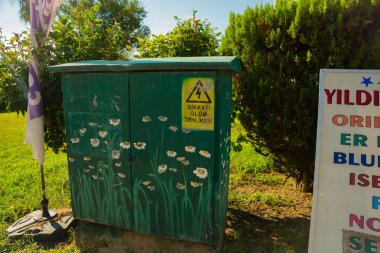 Trafo Kabine renklerle boyalı: Papatya yeşil bir arka plan üzerinde. Bir tehlike yüksek gerilim elektrik bir kutu olarak oturum açın. Alanya, Antalya bölgesinde, Türkiye, Asya