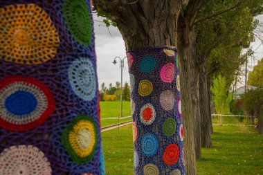 Beautiful knitted decor, protection from cold and insects on the trees in the Sazova Park or Science Art and Culture Park. Turkey, Eskisehir. clipart
