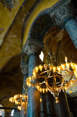 Istanbul, Türkiye: Ayasofya'nın iç. Sütunlar arasında ışık ampuller ile eski metal avize. Ayasofya'nın en büyük anıt Bizans kültürü olduğunu.