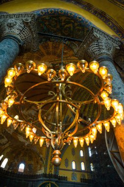 Istanbul, Türkiye: Ayasofya'nın iç. Sütunlar arasında ışık ampuller ile eski metal avize. Ayasofya'nın en büyük anıt Bizans kültürü olduğunu.