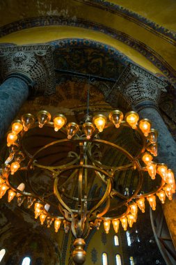 Istanbul, Türkiye: Ayasofya'nın iç. Sütunlar arasında ışık ampuller ile eski metal avize. Ayasofya'nın en büyük anıt Bizans kültürü olduğunu.