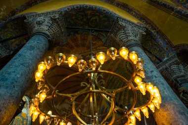 Istanbul, Türkiye: Ayasofya'nın iç. Sütunlar arasında ışık ampuller ile eski metal avize. Ayasofya'nın en büyük anıt Bizans kültürü olduğunu.