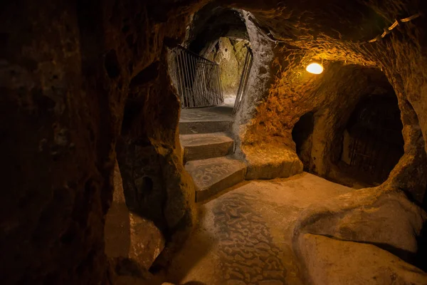 The Derinkuyu underground city is an ancient multi-level cave city in Cappadocia, Turkey. Stone used as a door in the old underground city. Green tour