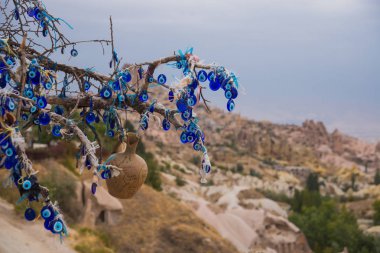 mavi boncuk karşı nazar tılsım gibi yıpranmış Kapadokya'da ağaçta güneşli bir günde astı. Cappadocia, Uçhisar, Türkiye.
