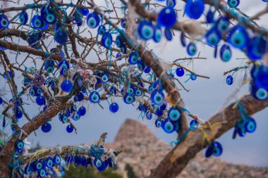Nazar ağacında Uçhisar Kalesi Kapadokya, Türkiye'de arkasında. Nazar muska, nazar karşı korumak özel bir göz şeklinde nesneleri asılı ağaç