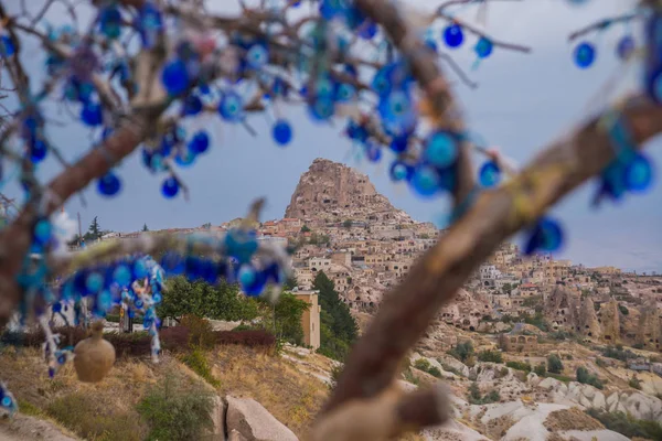 Evil eye in tree behind Uchisar Castle in Cappadocia, Turkey. Tree hanging Nazar amulets, a special eye-shaped objects that protect against the evil eye