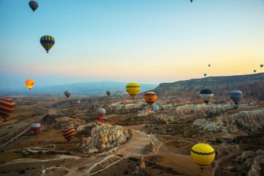 Kapadokya: Balon uçuş şafak, dağlar ve topları güzel manzara. Gökyüzünün altında muhteşem Cappadocia üzerinde uçan sıcak hava balonu.