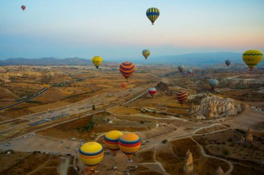 Kapadokya: Balon uçuş şafak, dağlar ve topları güzel manzara. Gökyüzünün altında muhteşem Cappadocia üzerinde uçan sıcak hava balonu.