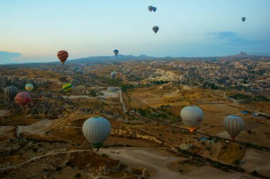 Kapadokya: Balon uçuş şafak, dağlar ve topları güzel manzara. Gökyüzünün altında muhteşem Cappadocia üzerinde uçan sıcak hava balonu.