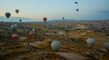 Kapadokya: Balon uçuş şafak, dağlar ve topları güzel manzara. Gökyüzünün altında muhteşem Cappadocia üzerinde uçan sıcak hava balonu.