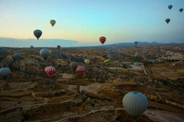 GOREME, TURKEY: Colorful Hot air balloons fly over Cappadocia, Goreme, Central Anatolia, Turkey. Hot-air ballooning is very popular tourist activity in Cappadocia.Balloon flight at dawn, beautiful view of the mountains and balls.