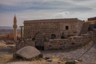Cadde ile eski şehir Uçhisar (Uchisar) Camii. Evleri hillside inşa edilir. Kapadokya, Anadolu, Nevşehir ili, Türkiye.