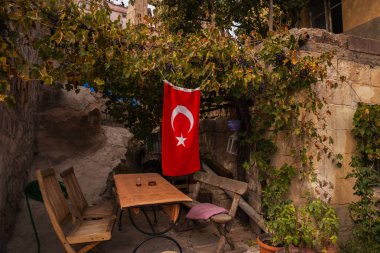 Ahşap Bank ve bir asma bir tezgah. Türk bayrağı. Kapadokya, Anadolu, Nevşehir ili, Türkiye.
