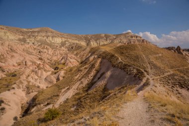 Rose valley, Güllüdere Vadisi kayalarda yolda. Mesafe beyaz dağ, Aktepe hill. Cappadocia, Anadolu, Türkiye. UNESCO Dünya Mirası.