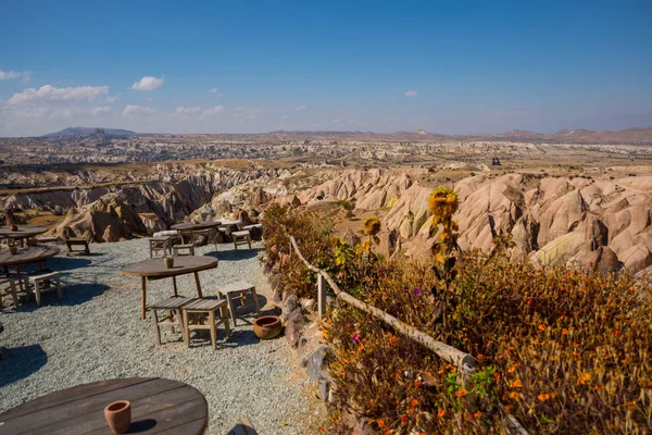 Tables and chairs for tourists on the observation deck. Travel to Turkey - observation deck on the Aktepe Hill and valley in Nevsehir province in Cappadocia, Anatolia.