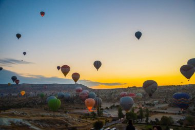 Kapadokya, Göreme, Anadolu, Türkiye. Gün batımı sıcak hava balonları bir dağ Kapadokya Göreme Milli Parkı Türkiye'nin turistik, vintage doğa arka plan iniş. Turistler için en sevdiğiniz eğlencelerin.