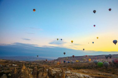 Güzel gündoğumu beyaz dağ, Aktepe Hill ve kırmızı ve pembe vadiler. Gökyüzünde uçan balonlar. En sevdiğiniz eğlencelerin turistler için. Kapadokya, Göreme, Anadolu, Türkiye.