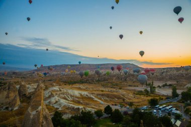 Güzel gündoğumu beyaz dağ, Aktepe Hill ve kırmızı ve pembe vadiler. Gökyüzünde uçan balonlar. En sevdiğiniz eğlencelerin turistler için. Kapadokya, Göreme, Anadolu, Türkiye.
