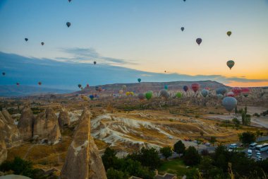 Kapadokya, Göreme, Anadolu, Türkiye. Güzel gündoğumu beyaz dağ, Aktepe Hill ve kırmızı ve pembe vadiler. Gökyüzünde uçan balonlar. Turistler için en sevdiğiniz eğlencelerin.