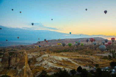 Kapadokya, Göreme, Anadolu, Türkiye. Güzel gündoğumu beyaz dağ, Aktepe Hill ve kırmızı ve pembe vadiler. Gökyüzünde uçan balonlar. Turistler için en sevdiğiniz eğlencelerin.