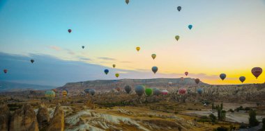 Güzel gündoğumu beyaz dağ, Aktepe Hill ve kırmızı ve pembe vadiler. Gökyüzünde uçan balonlar. En sevdiğiniz eğlencelerin turistler için. Kapadokya, Göreme, Anadolu, Türkiye.