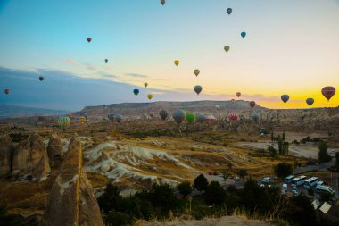 Güzel gündoğumu beyaz dağ, Aktepe Hill ve kırmızı ve pembe vadiler. Gökyüzünde uçan balonlar. En sevdiğiniz eğlencelerin turistler için. Kapadokya, Göreme, Anadolu, Türkiye.