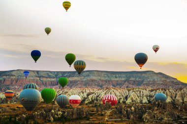 Güzel gündoğumu beyaz dağ, Aktepe Hill ve kırmızı ve pembe vadiler. Gökyüzünde uçan balonlar. En sevdiğiniz eğlencelerin turistler için. Kapadokya, Göreme, Anadolu, Türkiye.