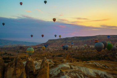 Güzel gündoğumu beyaz dağ, Aktepe Hill ve kırmızı ve pembe vadiler. Gökyüzünde uçan balonlar. En sevdiğiniz eğlencelerin turistler için. Kapadokya, Göreme, Anadolu, Türkiye.
