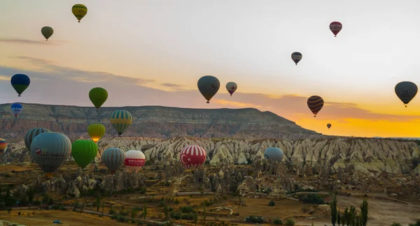 Güzel gündoğumu beyaz dağ, Aktepe Hill ve kırmızı ve pembe vadiler. Gökyüzünde uçan balonlar. En sevdiğiniz eğlencelerin turistler için. Kapadokya, Göreme, Anadolu, Türkiye.