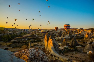 Kapadokya, Göreme, Anadolu, Türkiye. Cappadocia sunsrise gökyüzünde uçan parlak çok renkli sıcak hava balonu. Turistler için en sevdiğiniz eğlencelerin.
