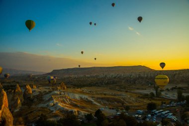 Cappadocia, Göreme, Anadolu, Turkey: Doğal canlı görünümü Kapadokya Vadisi'nin gündoğumu ışınları içinde balon uçuş. Dawn vadilerde güzel. Turistler için en sevdiğiniz eğlencelerin.