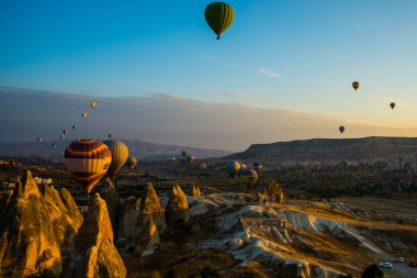 Cappadocia, Göreme, Anadolu, Turkey: Doğal canlı görünümü Kapadokya Vadisi'nin gündoğumu ışınları içinde balon uçuş. Dawn vadilerde güzel. Turistler için en sevdiğiniz eğlencelerin.