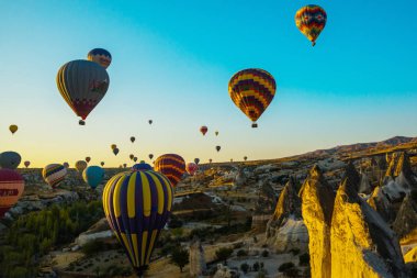 Cappadocia, Göreme, Anadolu, Turkey: Doğal canlı görünümü Kapadokya Vadisi'nin gündoğumu ışınları içinde balon uçuş. Dawn vadilerde güzel. Turistler için en sevdiğiniz eğlencelerin.