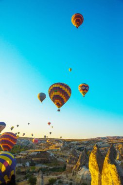 Kapadokya Göreme, Anadolu, Turkey: Birçok renkli sıcak hava balon balon fiesta, mavi gökyüzünde. Turistler için popüler ve favori eğlence. Paralel hareket hava ve karayolu taşıma.