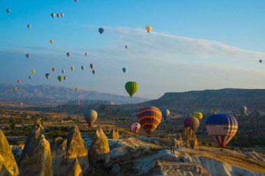 Cappadocia, Göreme, Anadolu, Turkey: Dağların üzerinden uçan sıcak hava balonları günbatımı Kapadokya, vintage doğa arka plan manzara. Turistler için popüler ve favori eğlence.