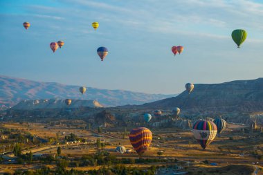 Cappadocia, Göreme, Anadolu, Turkey: Dağların üzerinden uçan sıcak hava balonları günbatımı Kapadokya, vintage doğa arka plan manzara. Turistler için popüler ve favori eğlence.