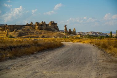 Yolun dağlar ve kayalar gibi mantar şeklinde yol açar. Peri bacaları. Cappadocia, Anadolu, Turkey.