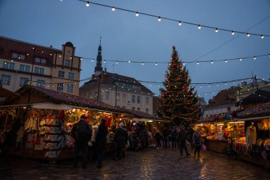 Tallinn, Estonya: İnsanlar Tallinn pazarda Noel tadını çıkarın. Gece manzara Hall ile Noel ağacı oluşturma ve aydınlatma Kulesi ile. Estonya en eski Noel pazarı ile 1441 için uzanan çok uzun bir geçmişi olduğunu.