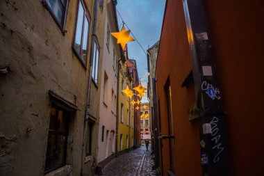 Yıldız çelenk ile eski şehir Riga, Letonya dar sokakta. Noel dekorasyon Avrupa sokakta. Rozena iela. Riga Şehir tarihi merkezinde bir Unesco Dünya mirası olduğunu