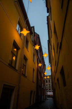 Yıldız çelenk ile eski şehir Riga, Letonya Rozena sokakta dar. Noel dekorasyon Avrupa sokakta. Rozena iela